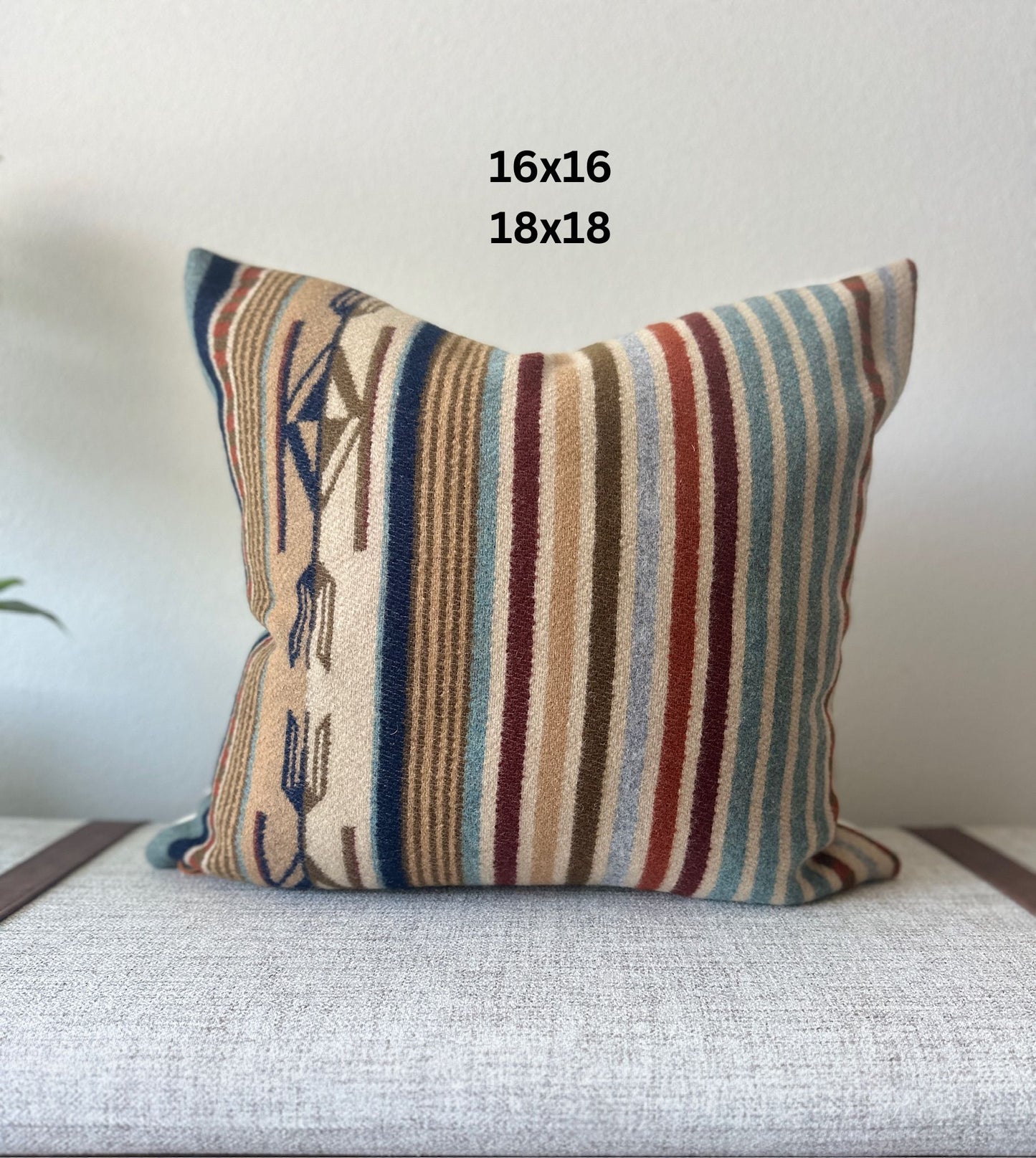 Striped pillow with geometric patterns on a light gray surface with 16x16 and 18x18 size dimensions showing