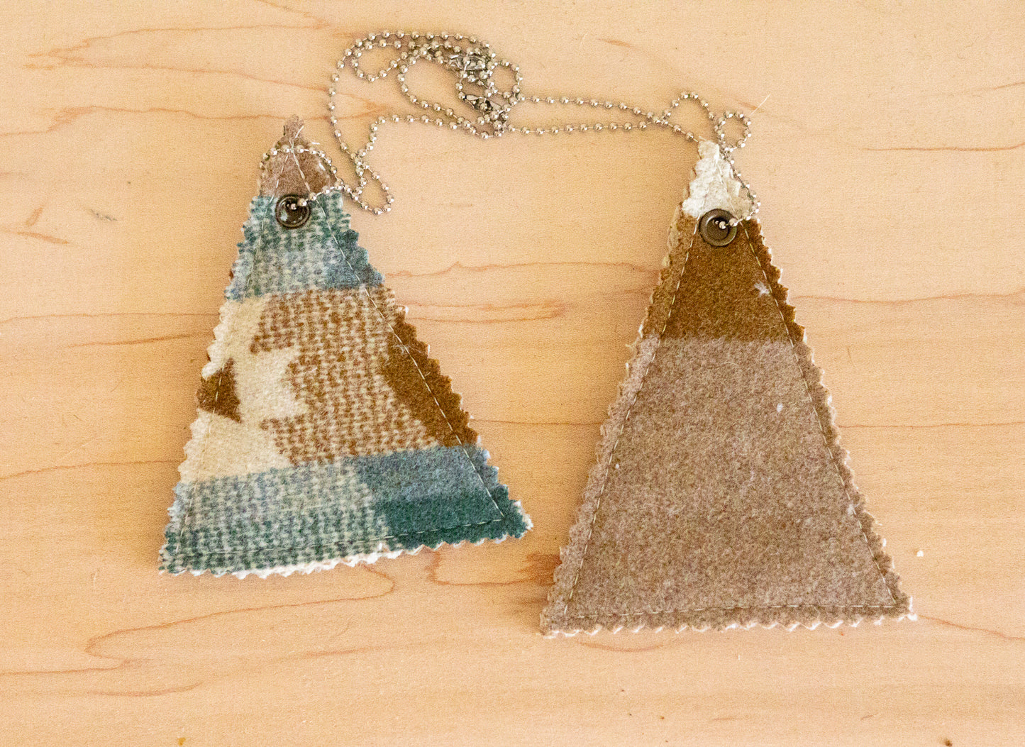 Two triangle-shaped decorative items on a wooden surface