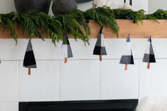 Decorative garland with black and white geometric shapes on a white wall.