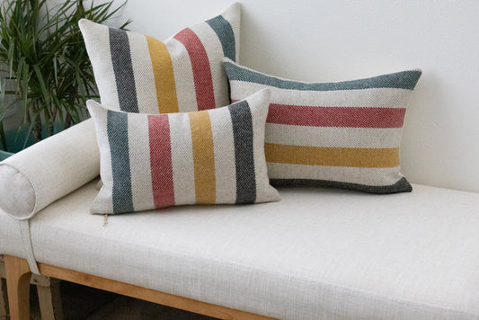 Striped cushions on a white sofa with a plant in the background