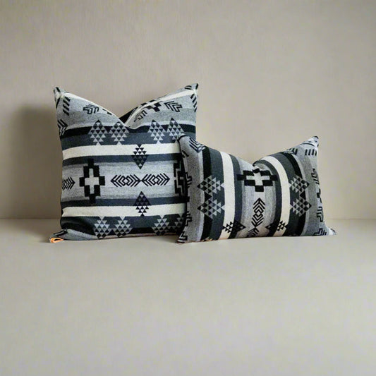 Decorative pillows with southwestern patterns on a soft gray background