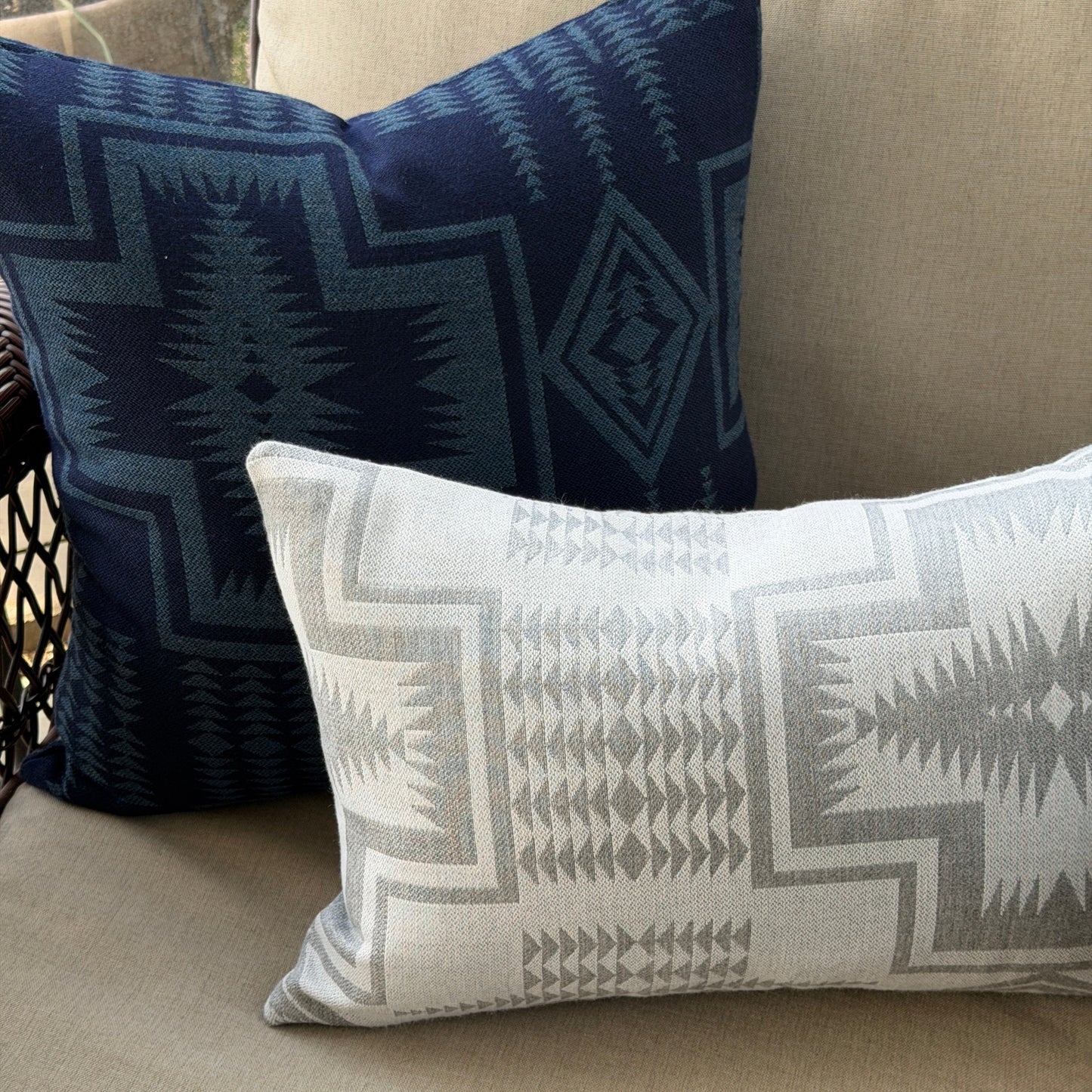 Two patterned pillows on a beige couch