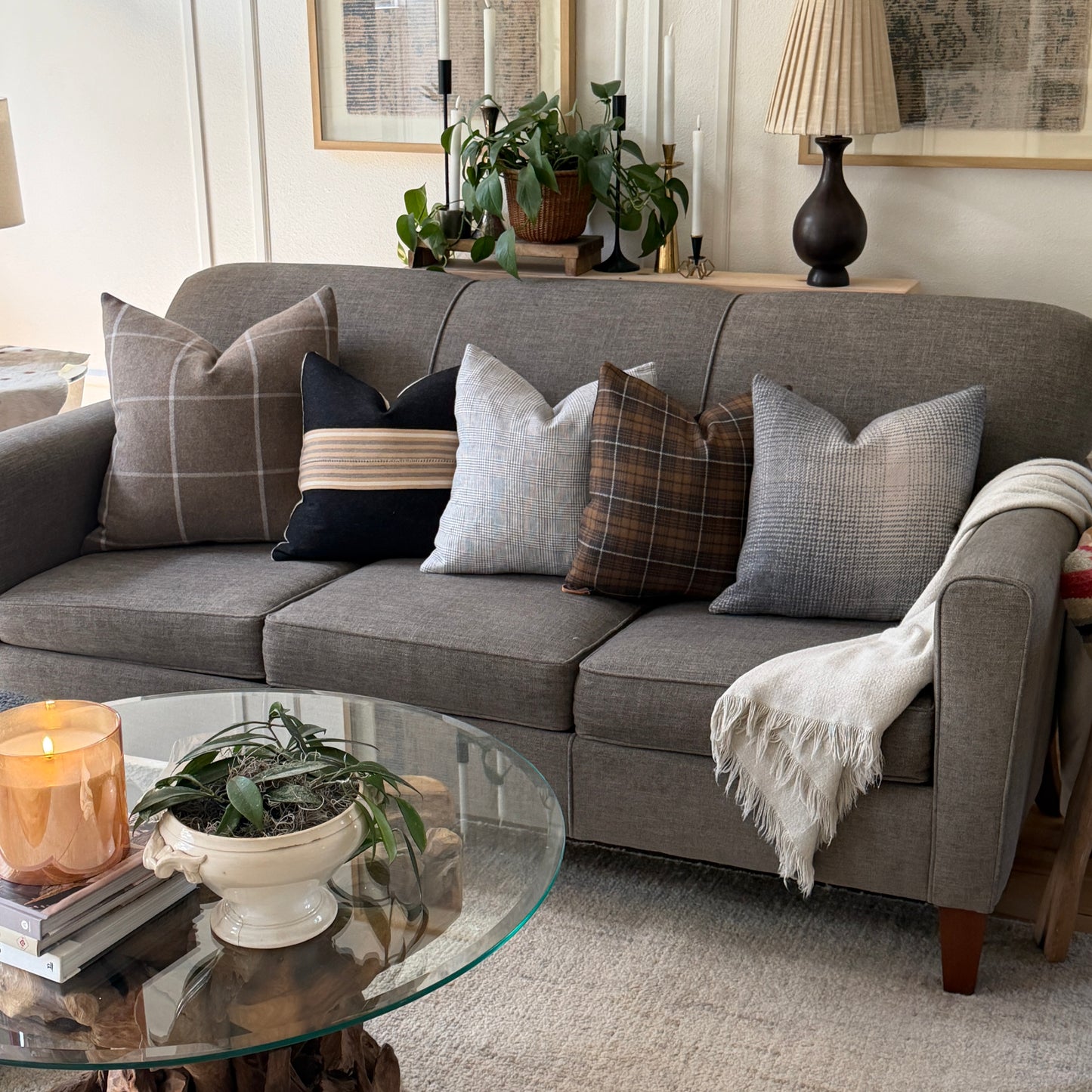 Gray sectional sofa with decorative pillows in a living room setting.