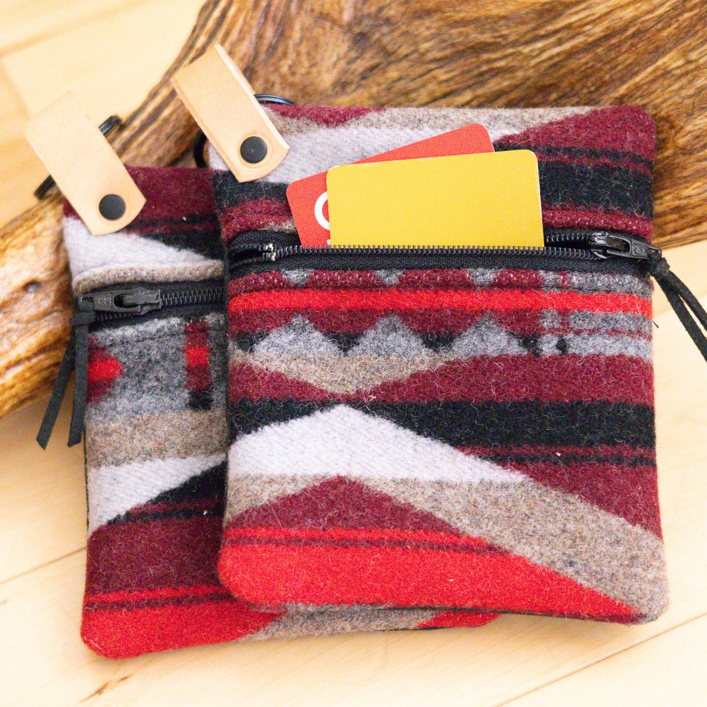 Two patterned pouches with zippers on a wooden surface