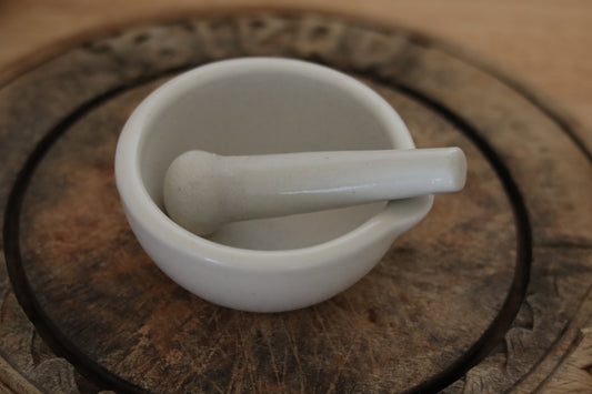 White ceramic mortar and pestle on a wooden surface