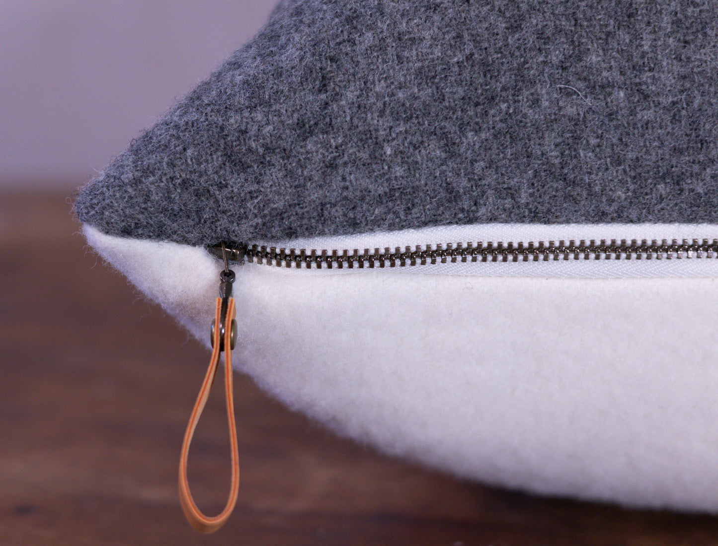 Close-up of a gray and white pillow with a zipper detail.