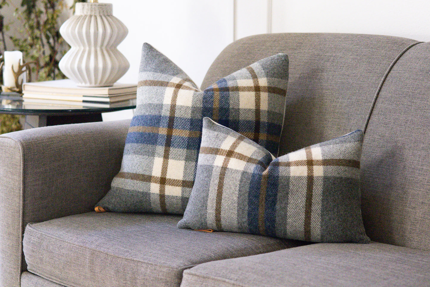 Gray sofa with plaid patterned cushions in a home setting