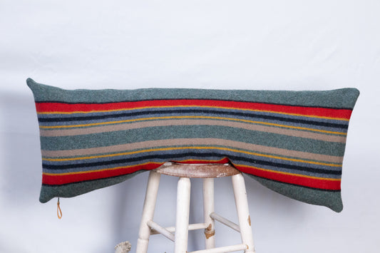 Green Heather Yakima Camp Wool long lumbar pillow cover, handcrafted from Pendleton blanket wool with forest-inspired stripes, displayed on a stool
