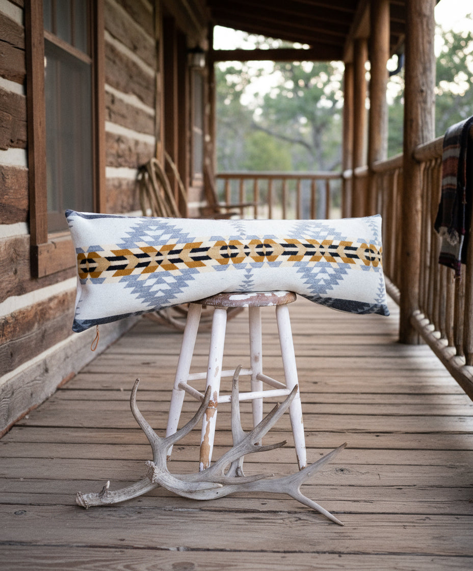 Decorative pillow with geometric pattern on a stool against a white background