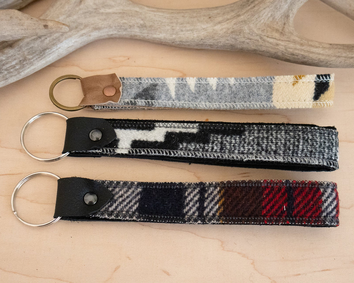 Three keychains with different patterns on a wooden surface