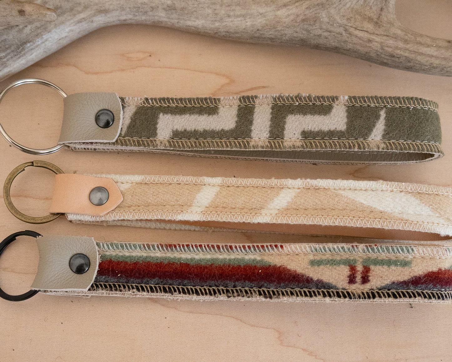 Three keychains with different patterns on a wooden surface
