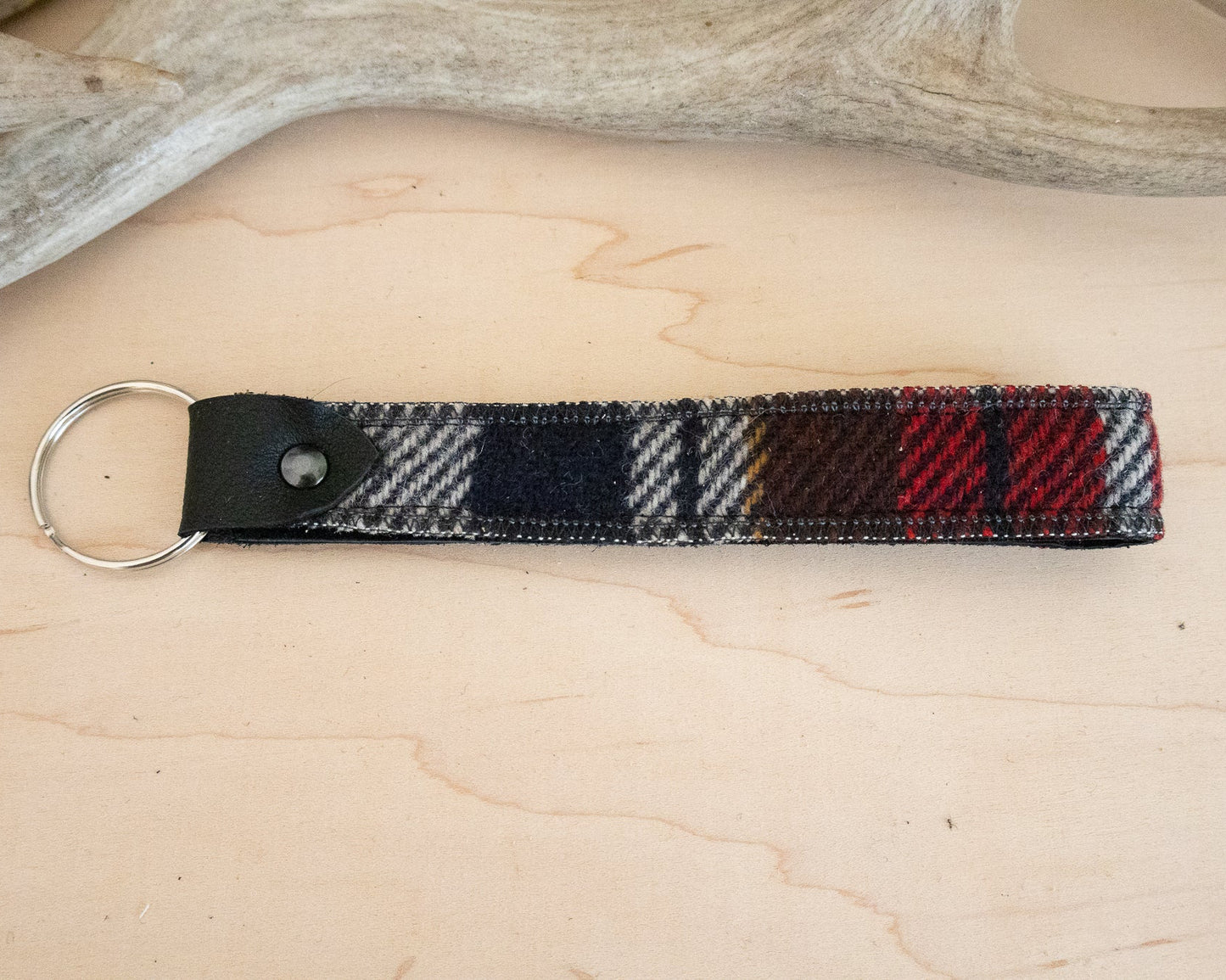 Plaid keychain with metal ring on a light wooden surface