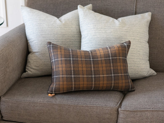 Charcoal plaid wool lumbar pillow cover styled in front of two neutral stripe wool pillow covers