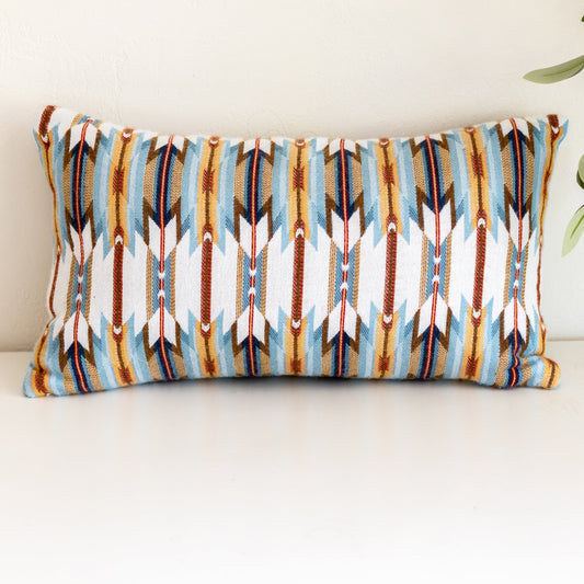 Decorative pillow with tribal pattern on a white surface