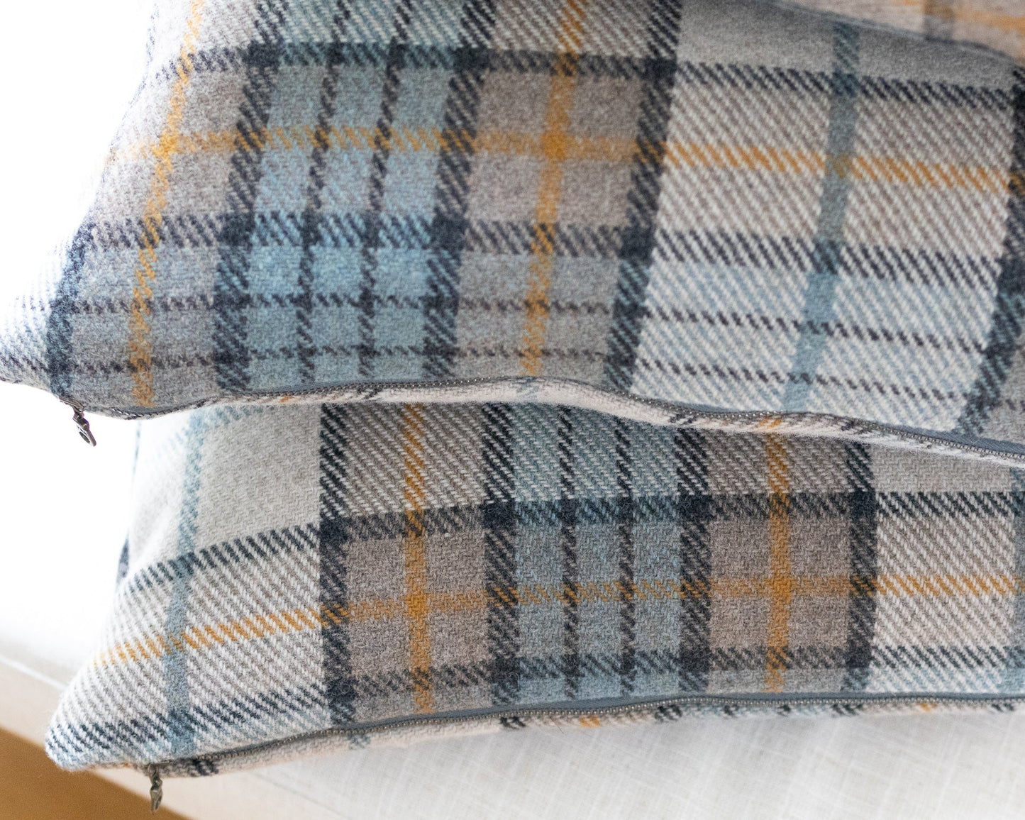 Plaid patterned fabric with blue, gray, and yellow colors on a white background