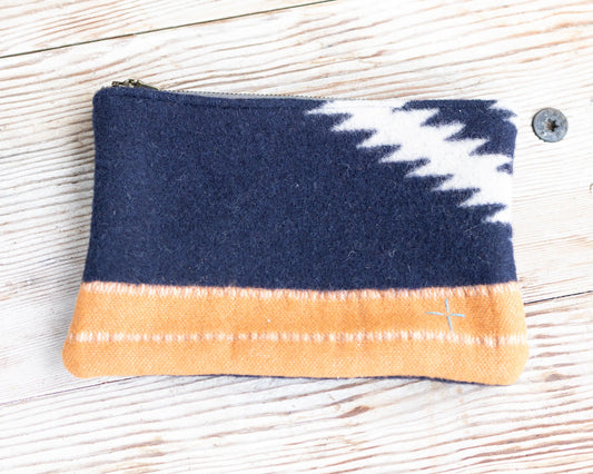 Fabric pouch with blue, white, and orange pattern on a wooden surface