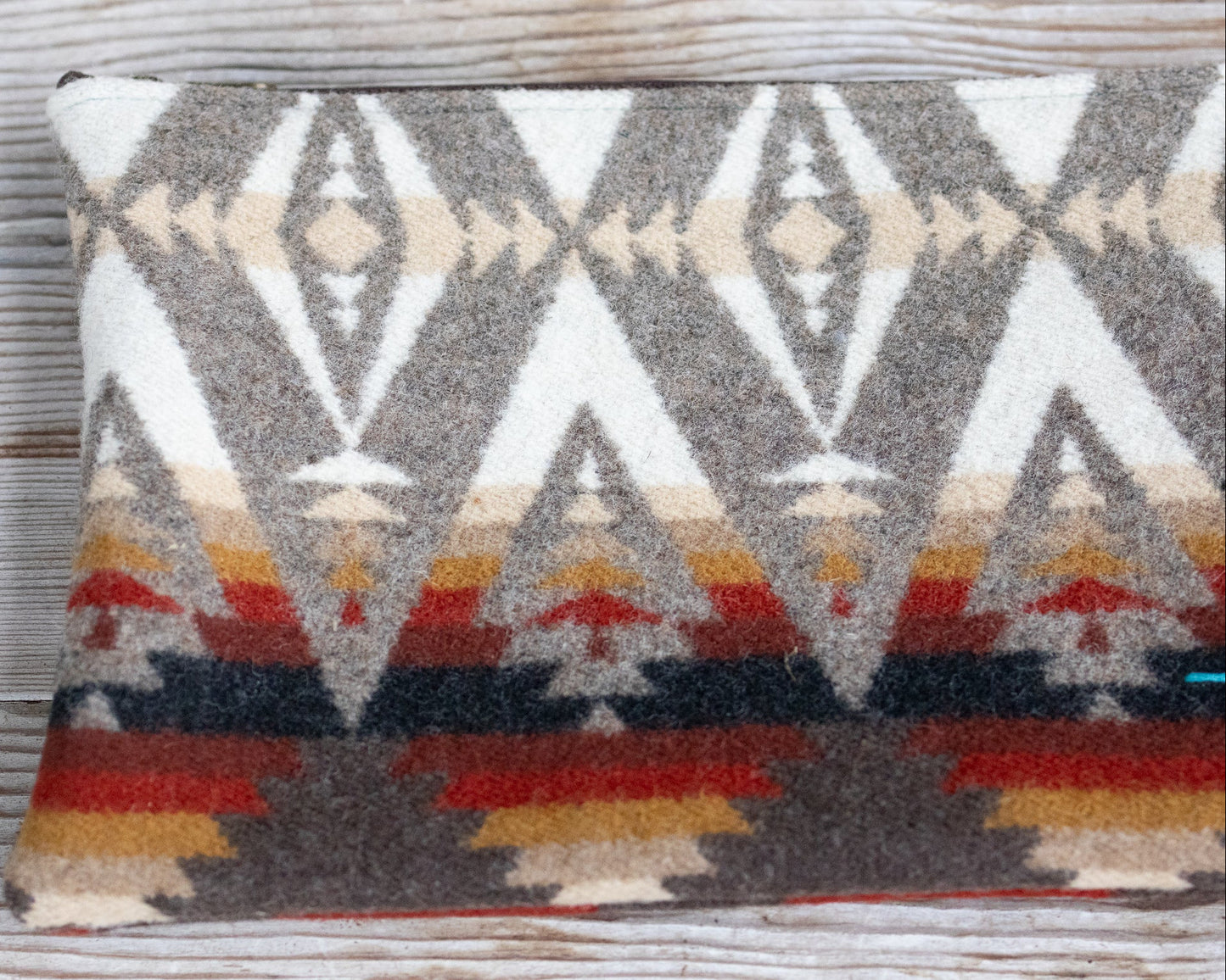 Decorative pillow with geometric pattern on a wooden surface