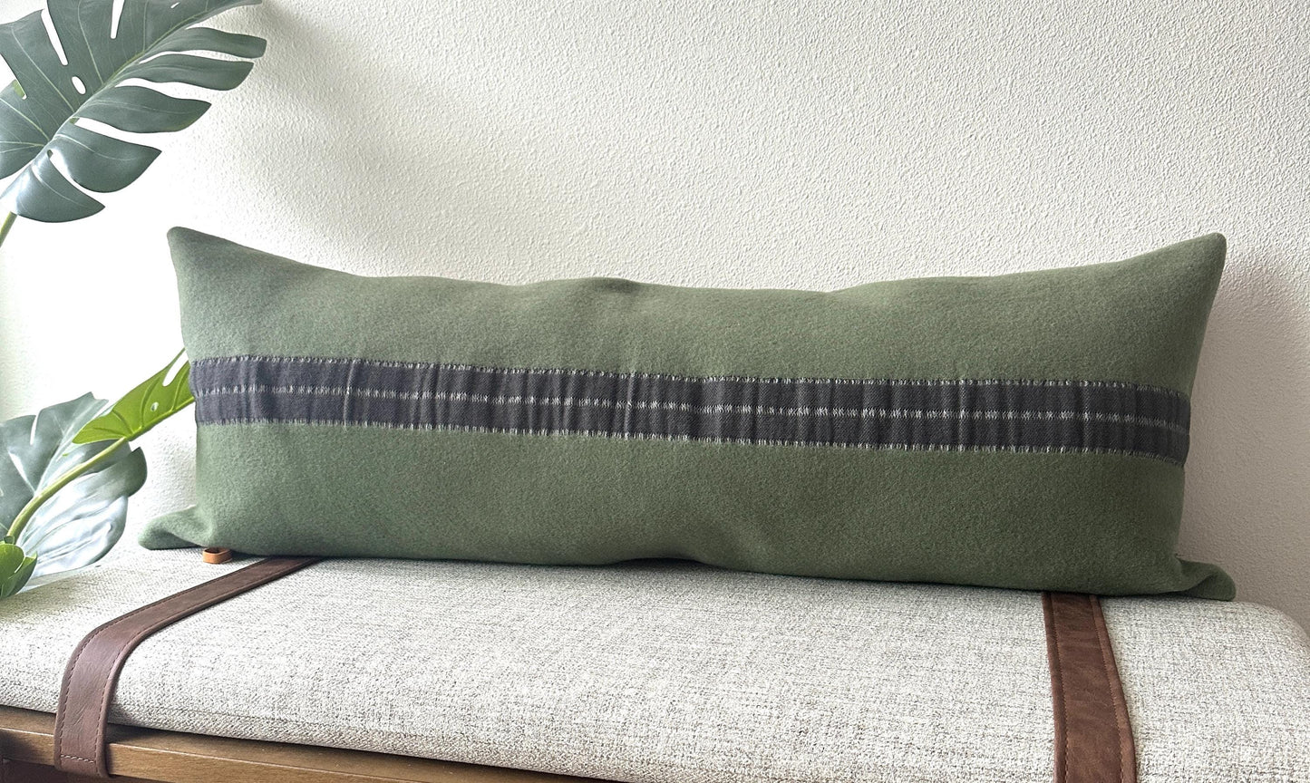 Green pillow with a long gray stripe on a bench