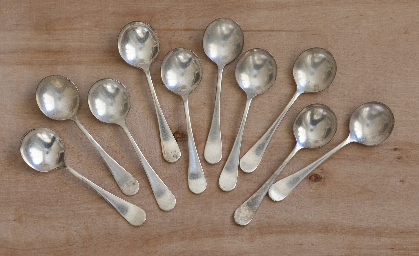 Set of silver spoons on a wooden surface
