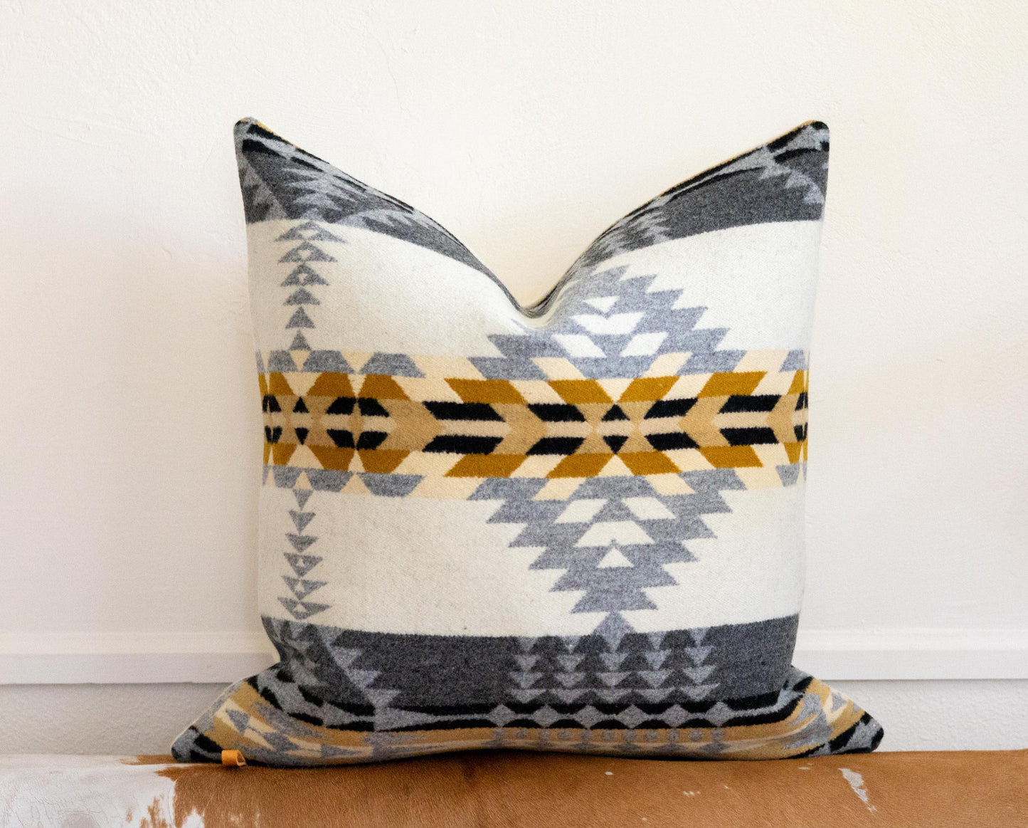 Decorative pillow with geometric pattern on a wooden surface