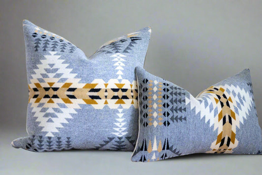 Two patterned pillows on a couch against a white wall