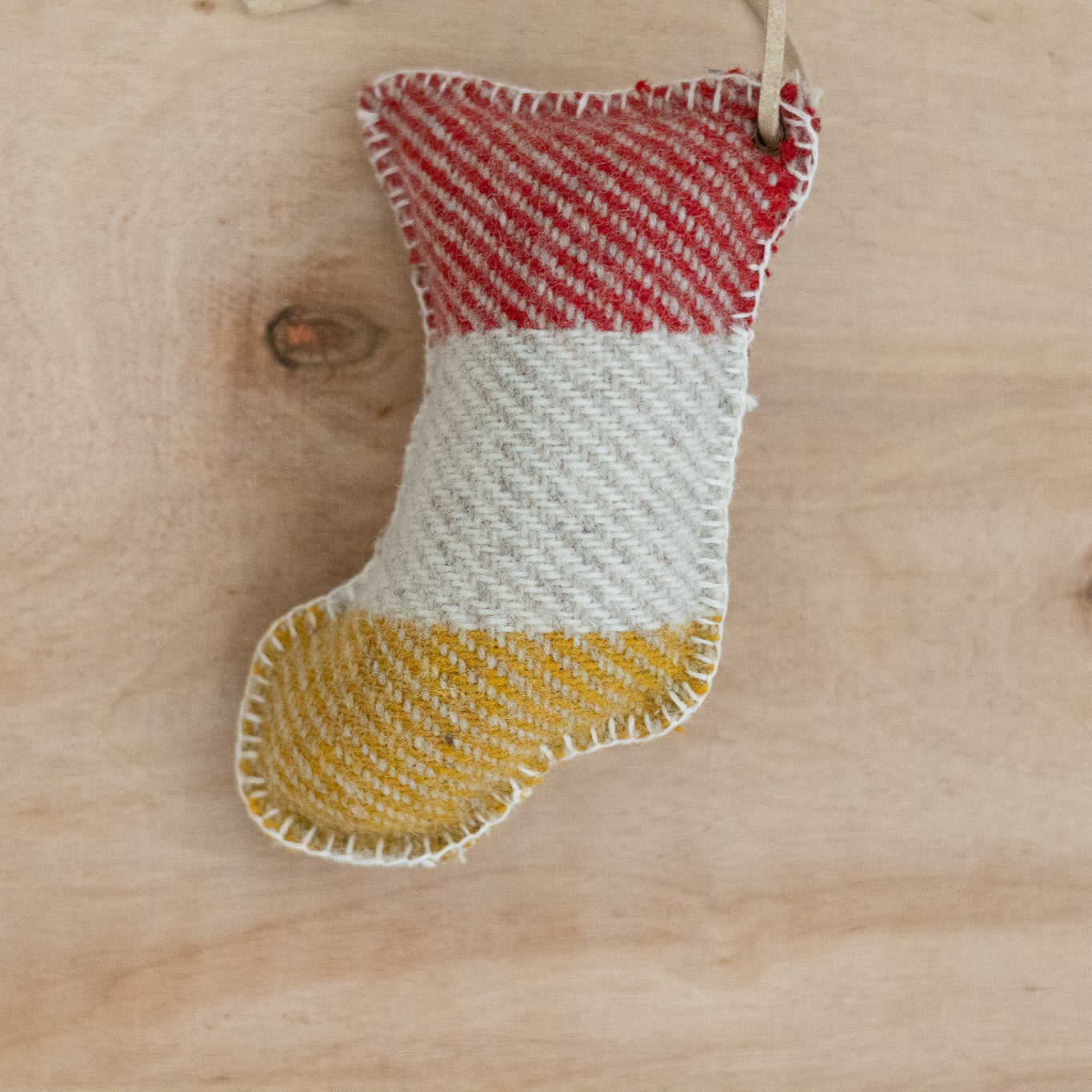 Pendleton wool stocking with red, white, and yellow pattern on a wooden surface