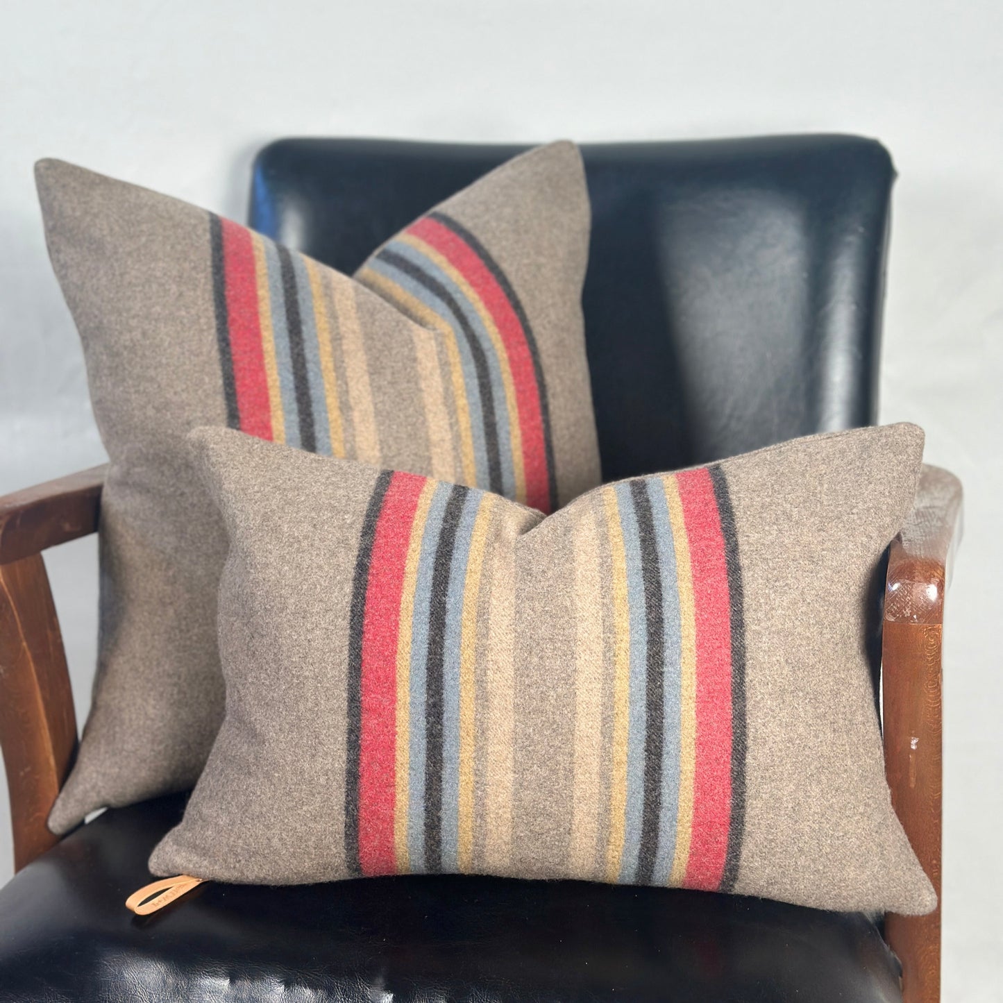 Striped cushions on a black leather chair with a white background