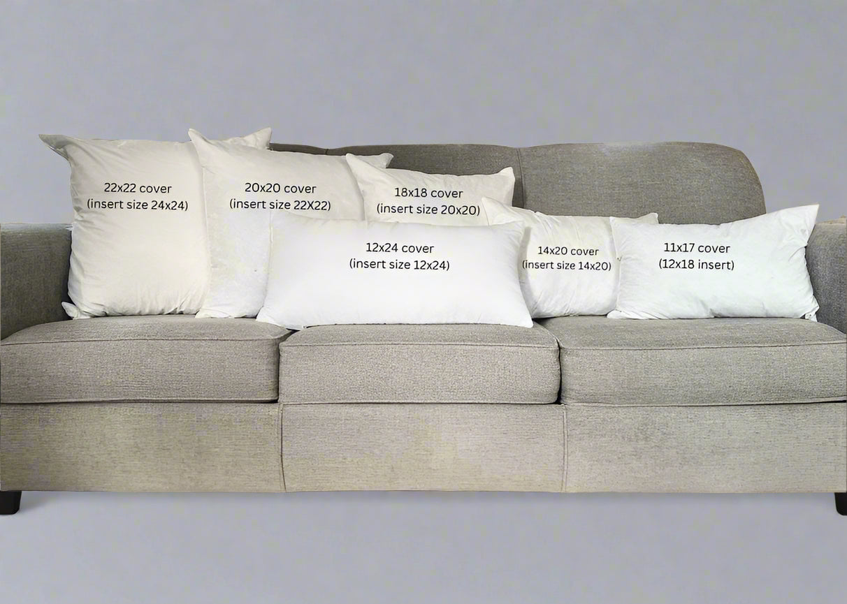 Gray sofa with decorative pillows displaying measurements in a living room.