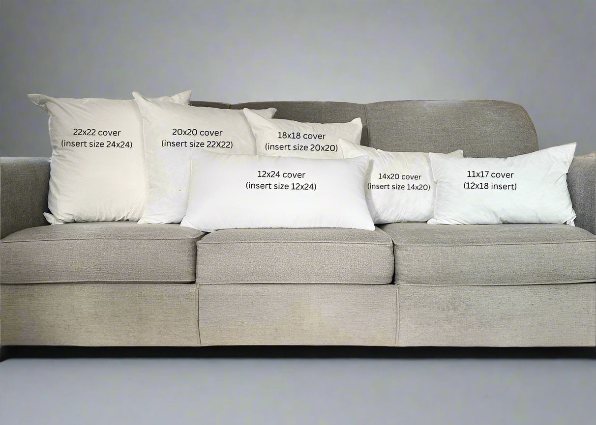 Gray sofa with decorative pillows displaying measurements in a living room.