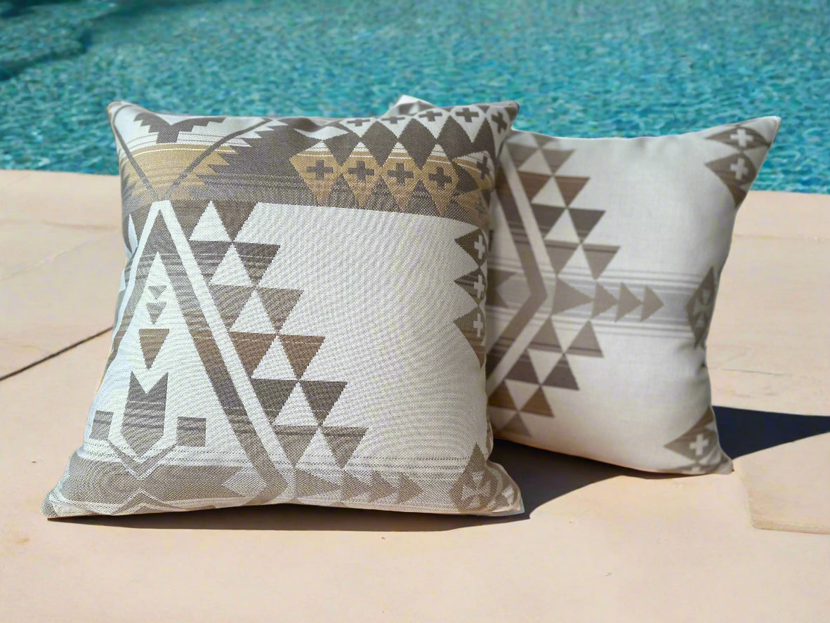 Two patterned pillows on a wooden surface with a blurred background