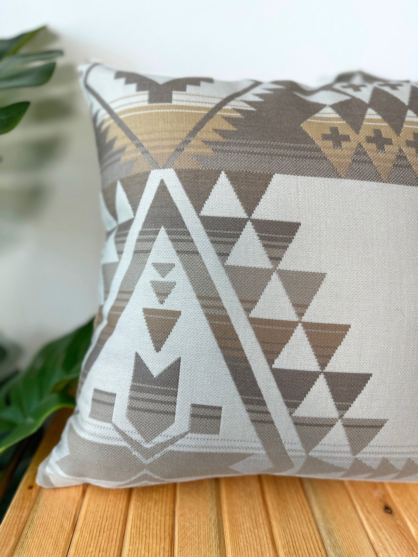 Decorative pillow with geometric pattern on a wooden surface