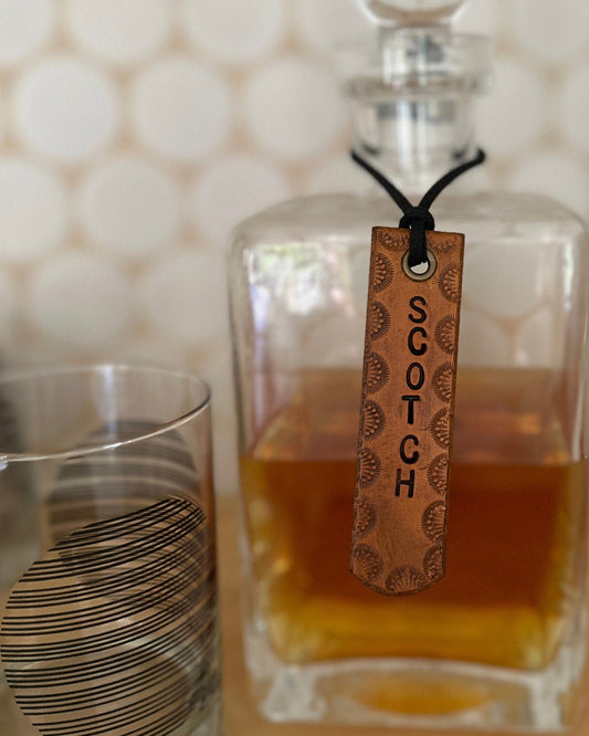 Glass decanter of Scotch with a glass on a textured surface