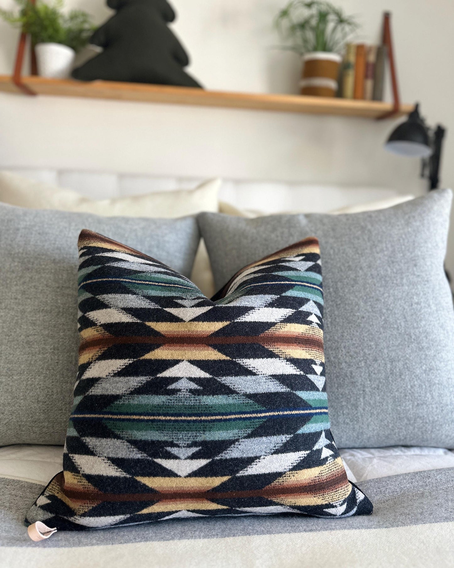 Geometric patterned pillow on a gray sofa with a blurred background