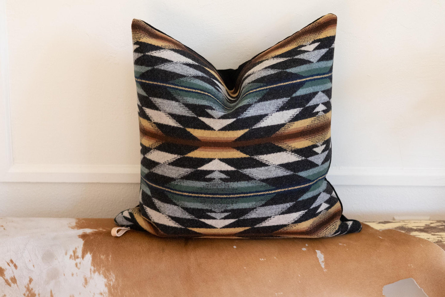 Decorative pillow with geometric pattern on a wooden surface