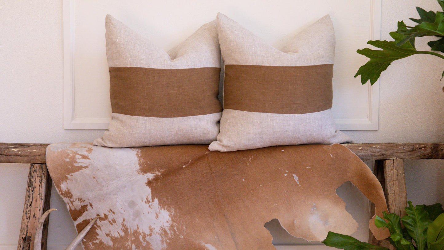 two linen pillows with copper band on natural linen base