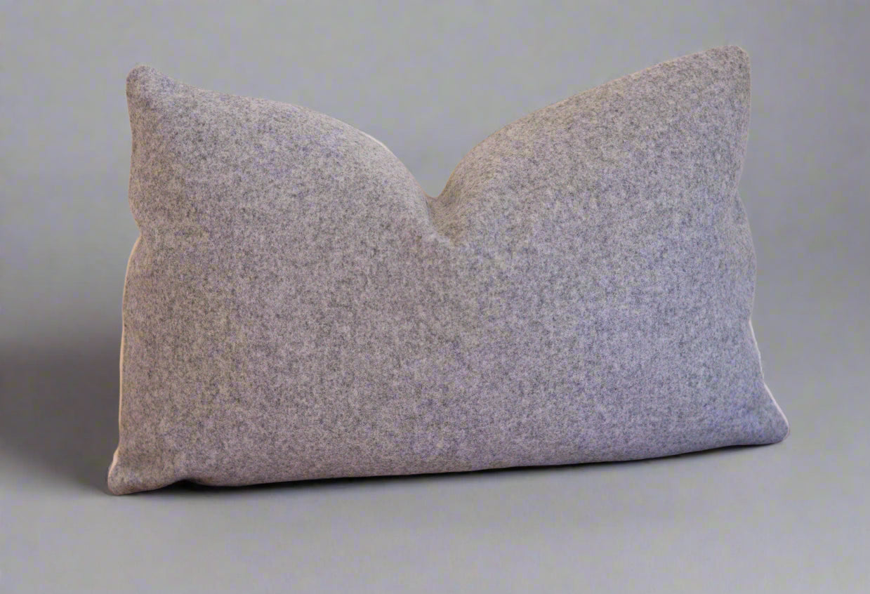 Gray textured pillow on a gray wall background