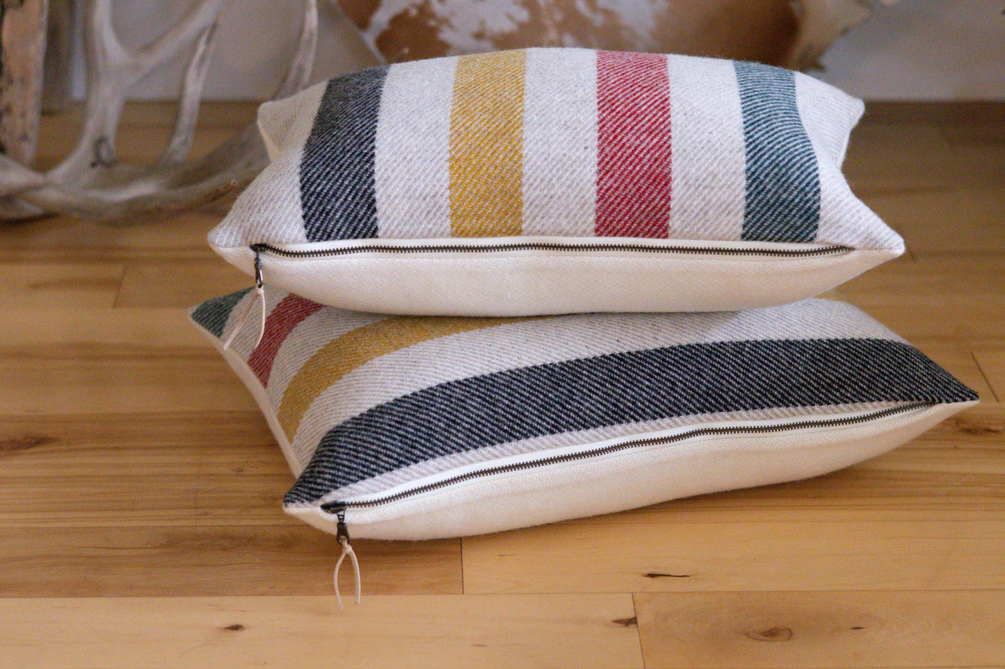 Two striped pillows on a wooden surface