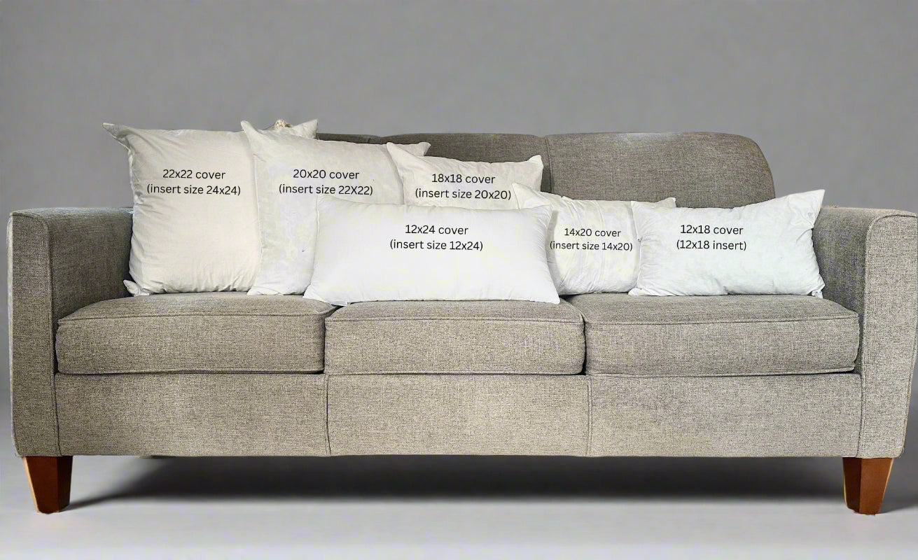 Gray sofa with decorative pillows and measurements printed on them in a living room setting.