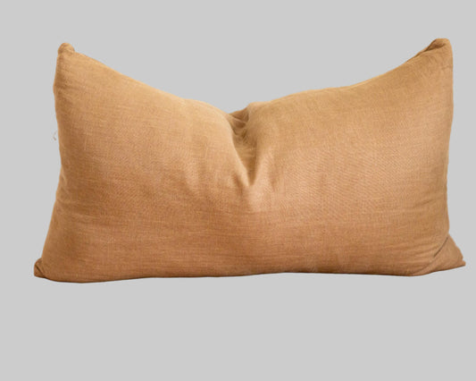 Brown pillow on a textured surface with a neutral background