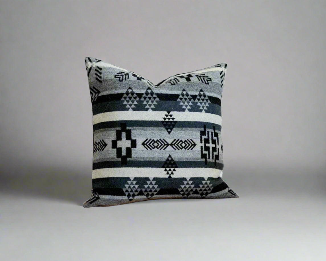 Decorative pillow with geometric pattern on a wooden surface