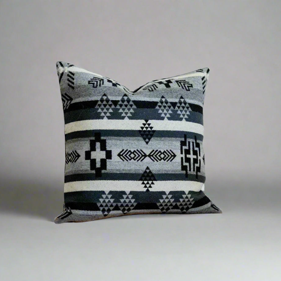 Decorative pillow with geometric pattern on a wooden surface