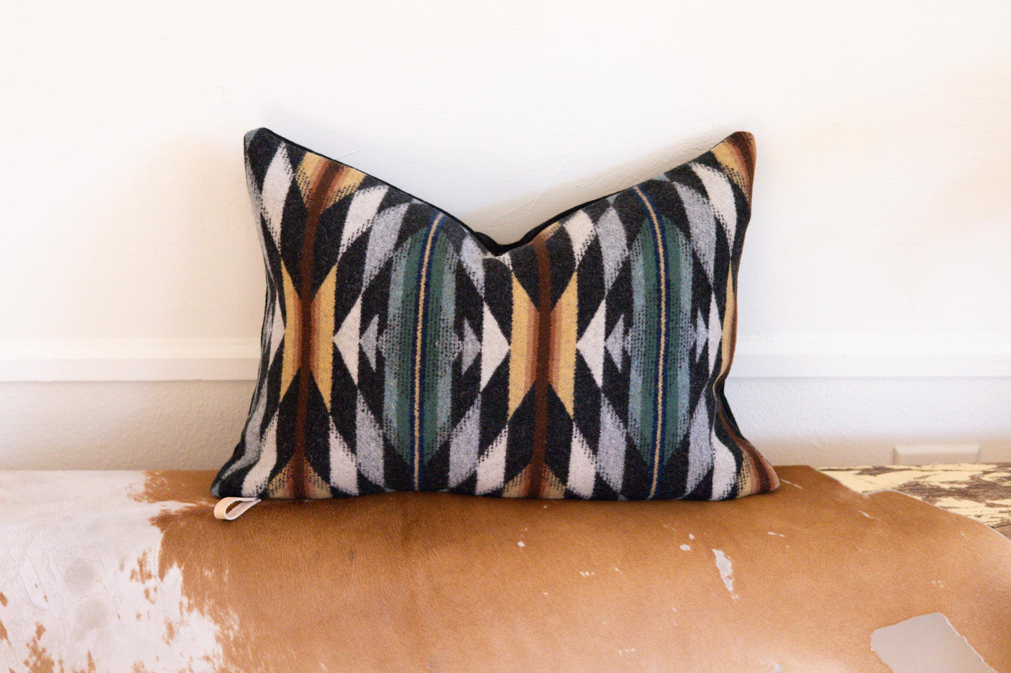 Decorative pillow with geometric pattern on a wooden surface