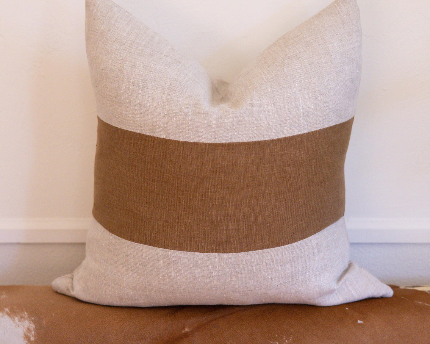 Decorative pillow with a brown band on a white background