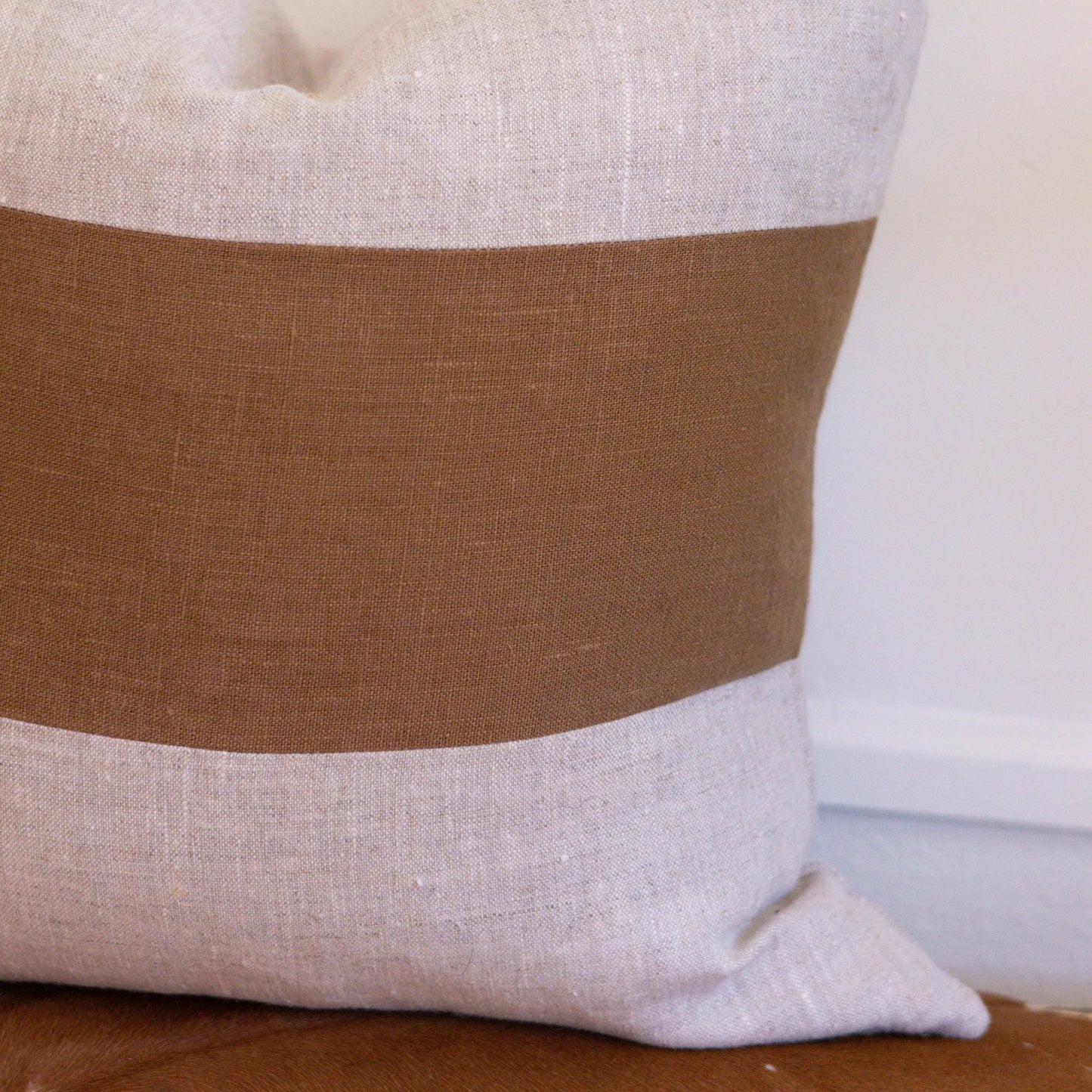 Decorative pillow with brown and beige stripes on a white background