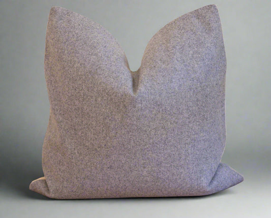 Gray textured pillow on a brown surface with a white background