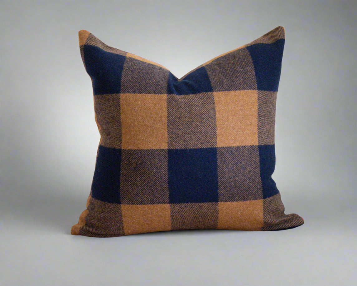 Plaid pillow with blue and brown pattern on a white background