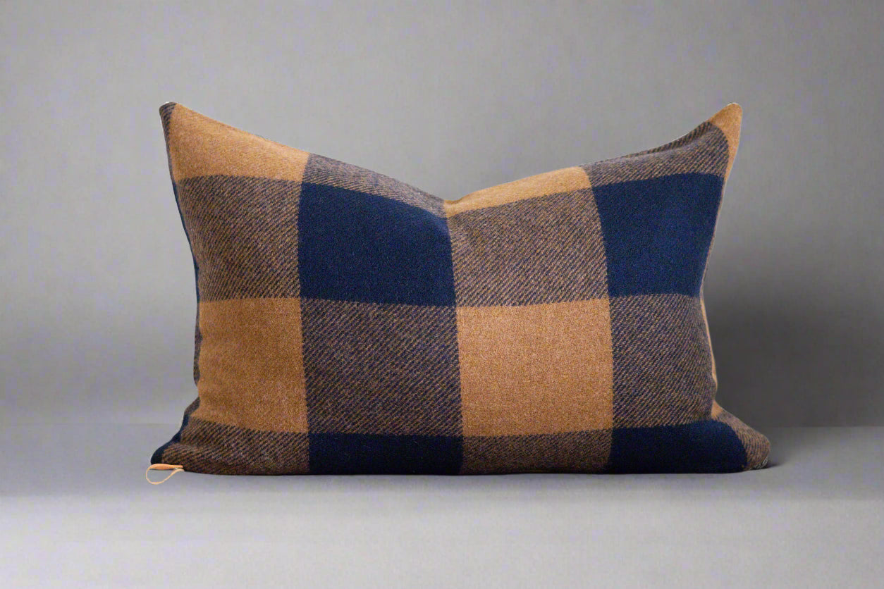 Plaid pillow with brown and blue pattern on a white background