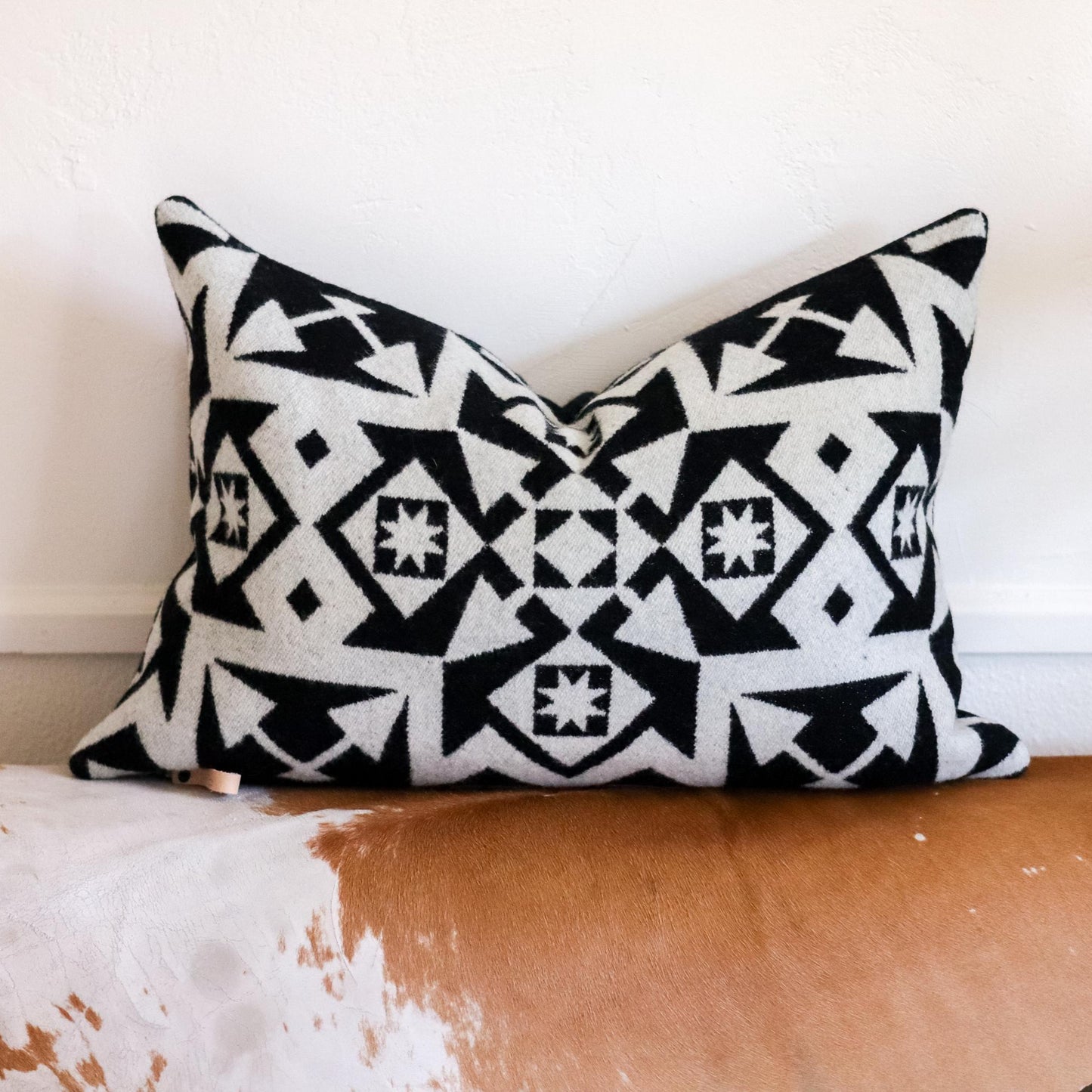Black and white patterned pillow on a wooden surface