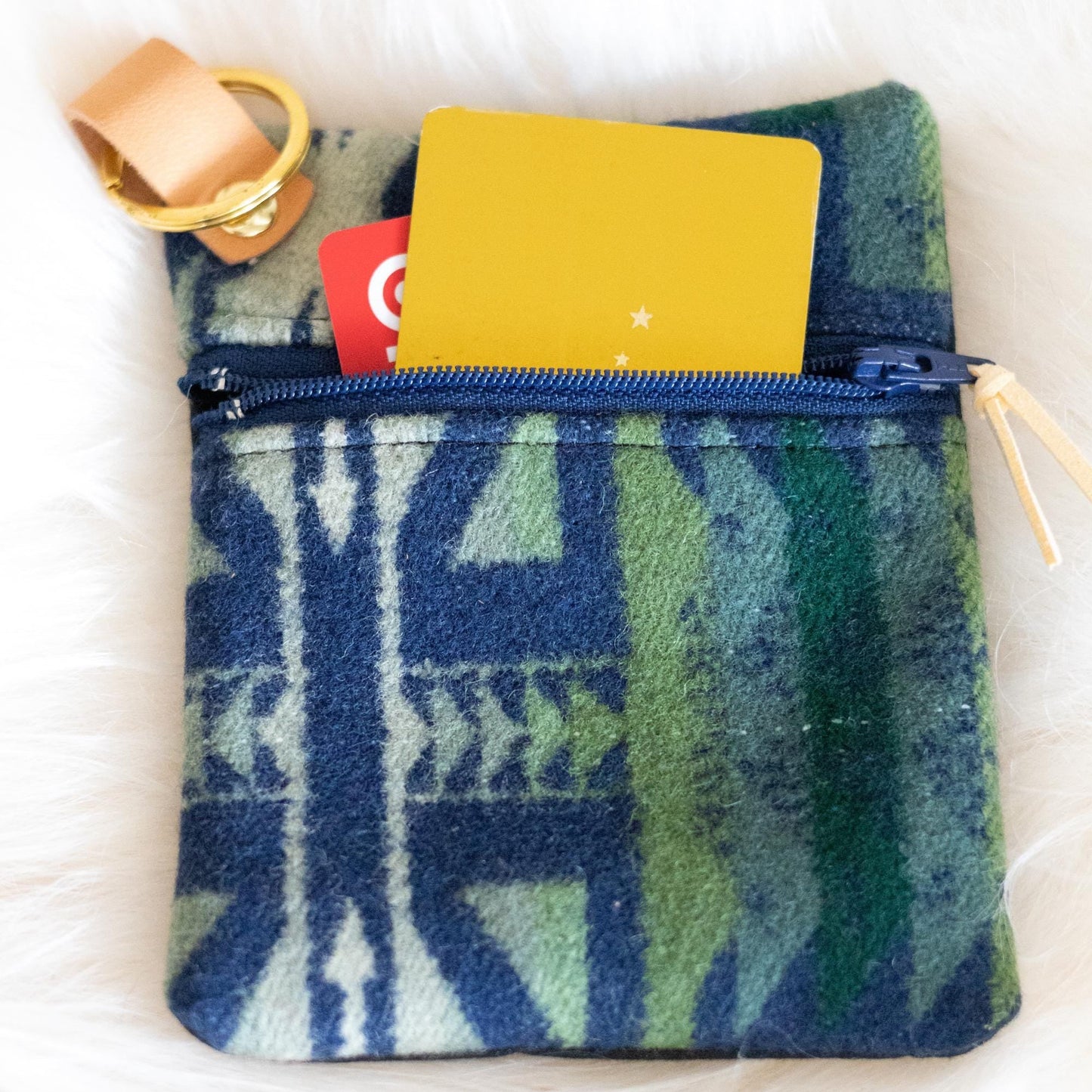Blue and green patterned pouch with a yellow card on a white background