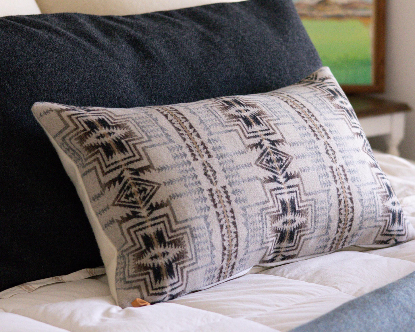 Decorative Pendleton® pillow with tribal pattern on a bed